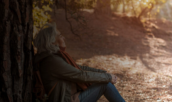 Woman sitting next to tree